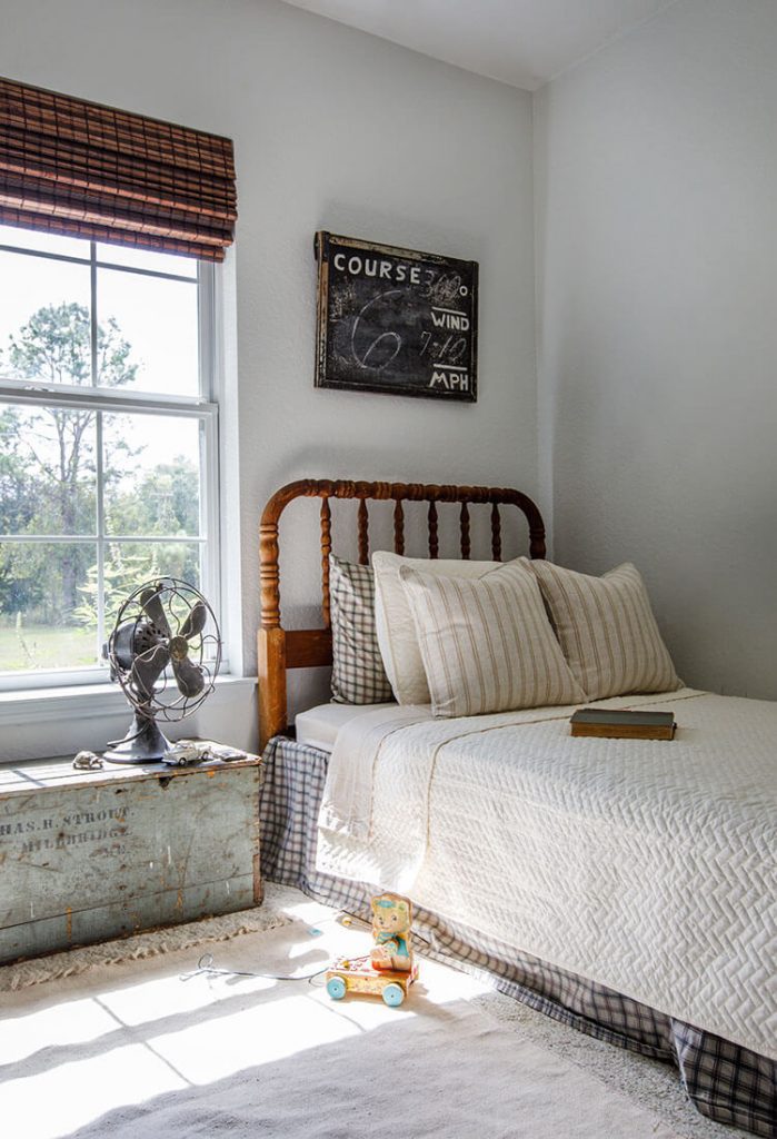 Bedroom with white bed and vintage sign above the bed