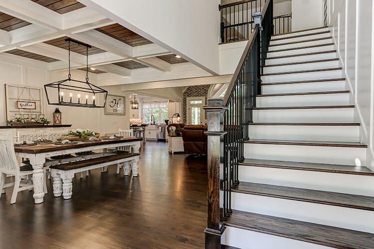 Staircase leading upstairs, next to dining room with set table