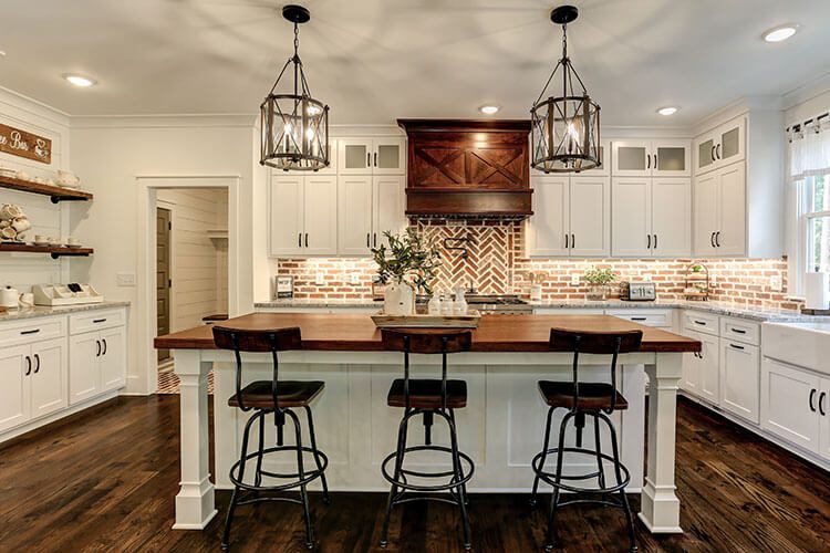 Custom modern farmhouse kitchen with brick backsplash and dark wood island