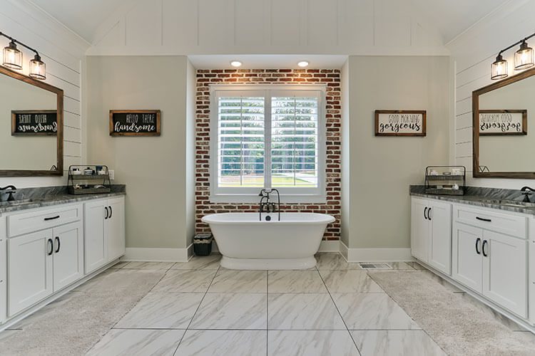 Custom modern farmhouse bathroom with freestanding sink and brick