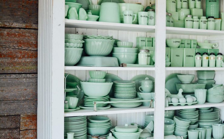 White cupboard full of green Jaedite dishware