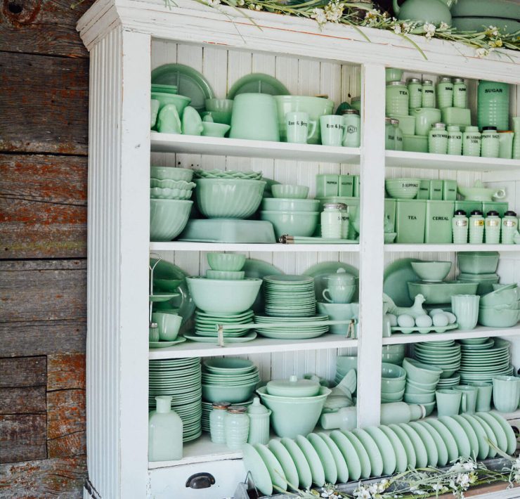 White cupboard full of green Jaedite dishware