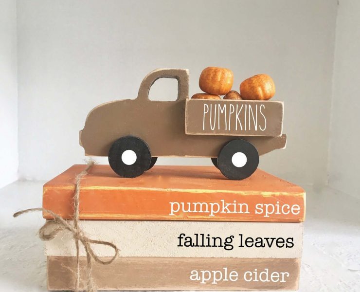 Staack of painted books with fall words and miniature truck with pumpkins