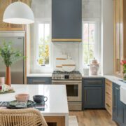 Modern farmhouse kitchen with blue and gold accents and rattan chair
