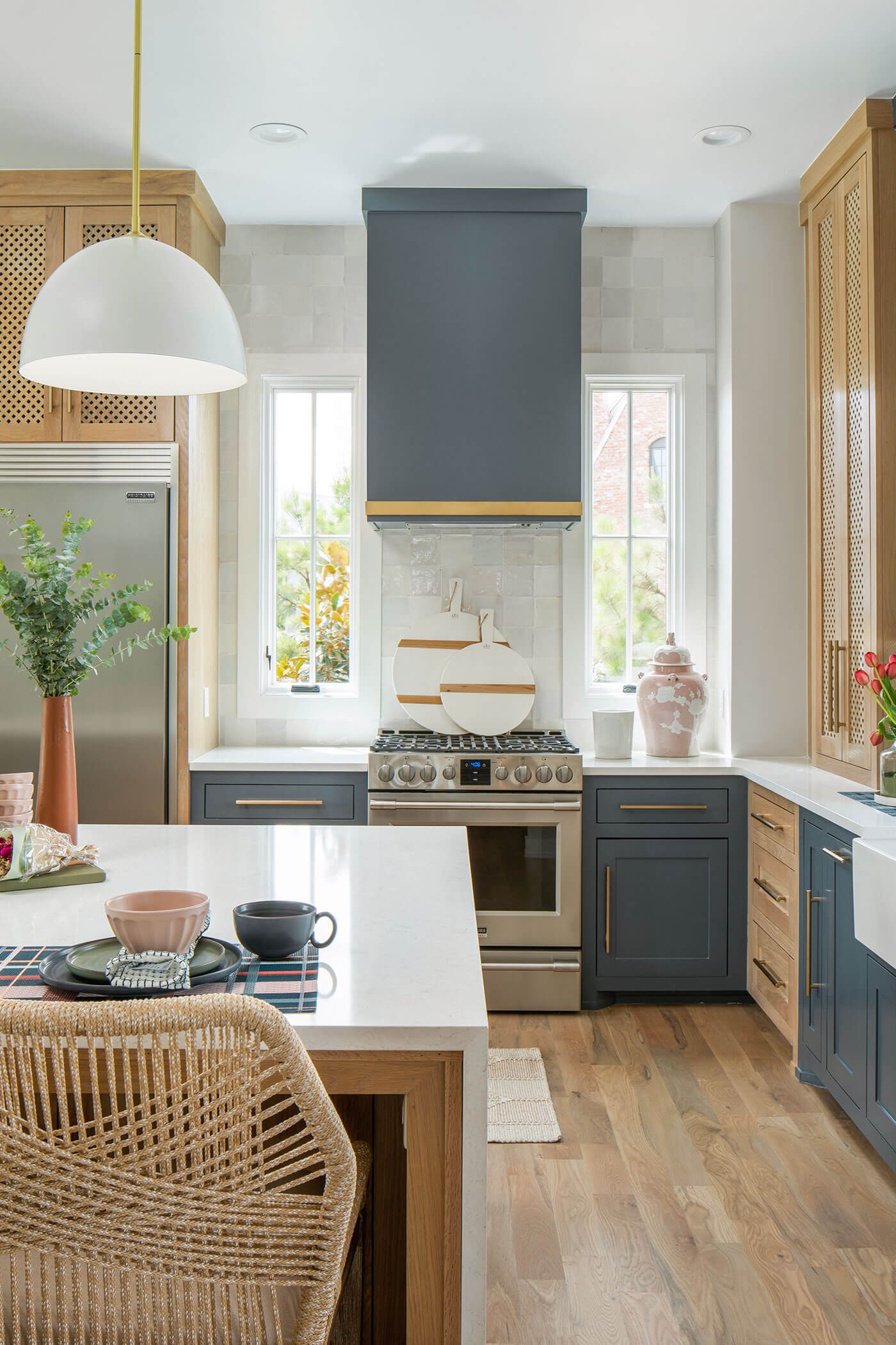 Modern farmhouse kitchen with blue and gold accents and rattan chair