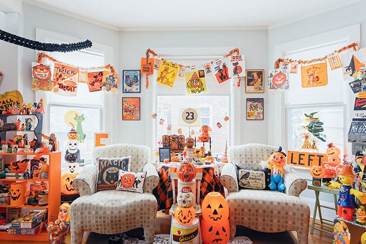 Living room with vintage Halloween collectibles displayed on shelves and above the windows