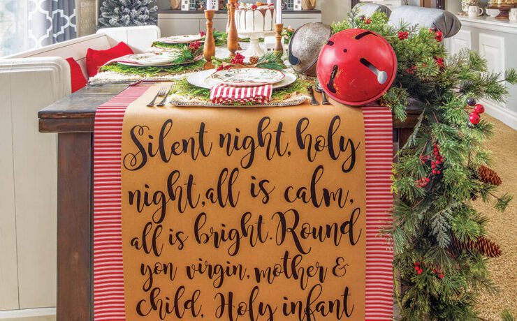 Dining table with Christmas garland, sign art and set table