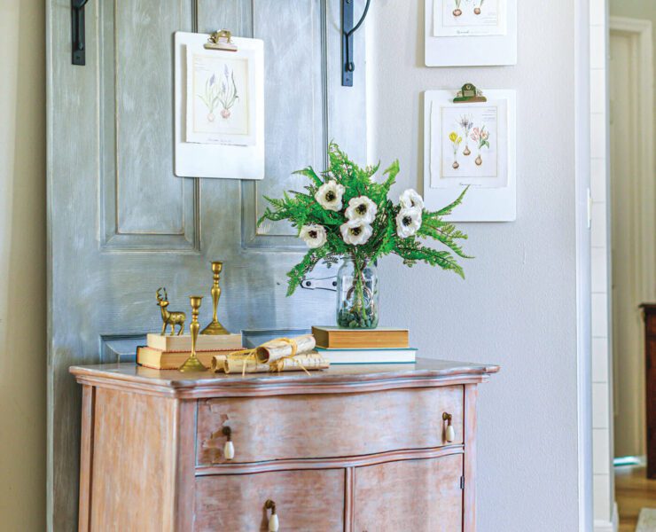 Vintage farmhouse style hallway with chippy dresser and vintage botanical prints on the wall