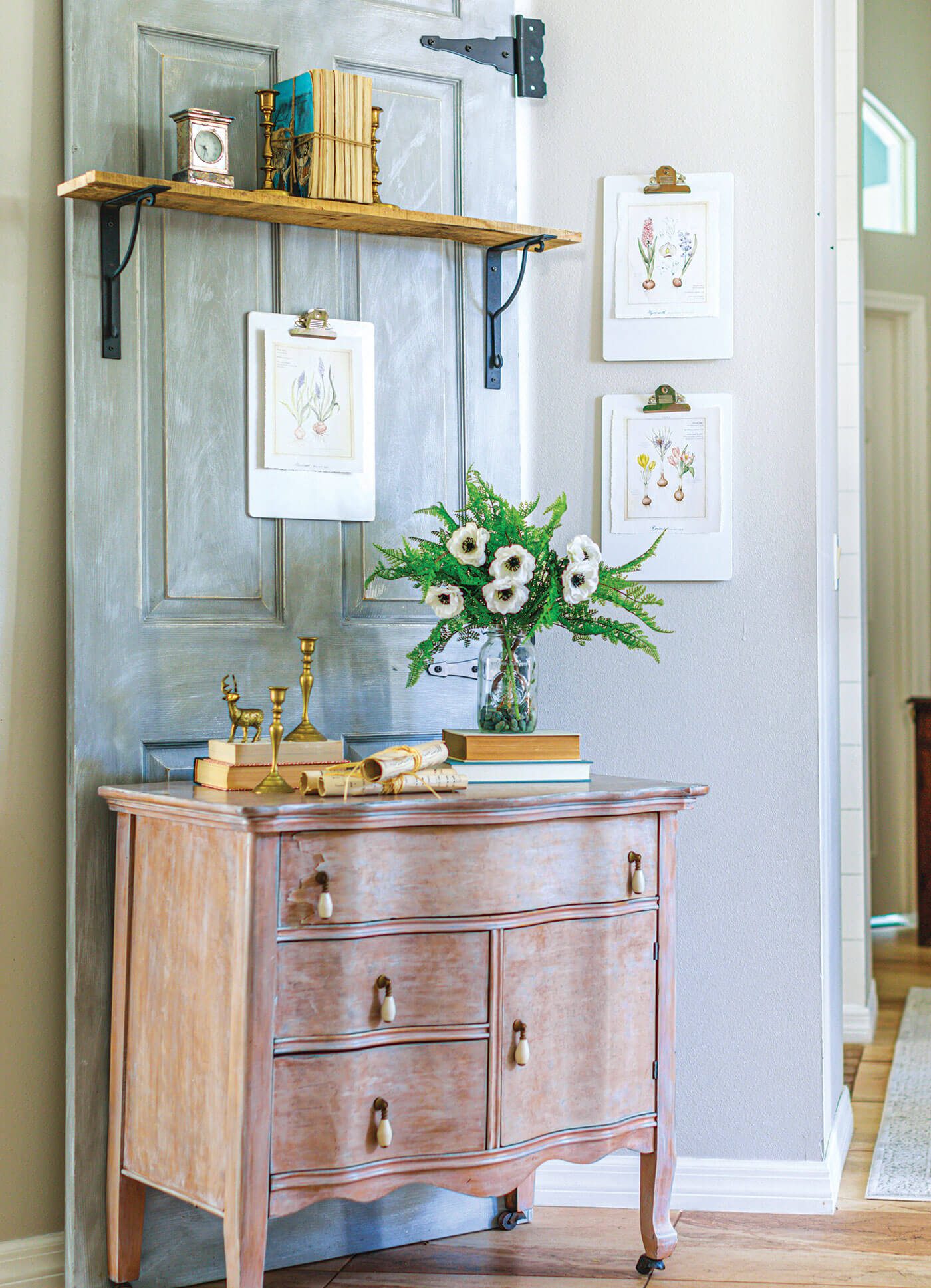 Vintage farmhouse style hallway with chippy dresser and vintage botanical prints on the wall