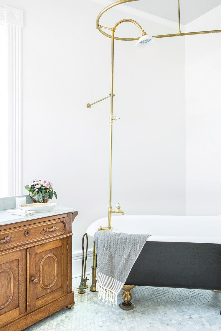 claw-foot tub with gold shower rod
