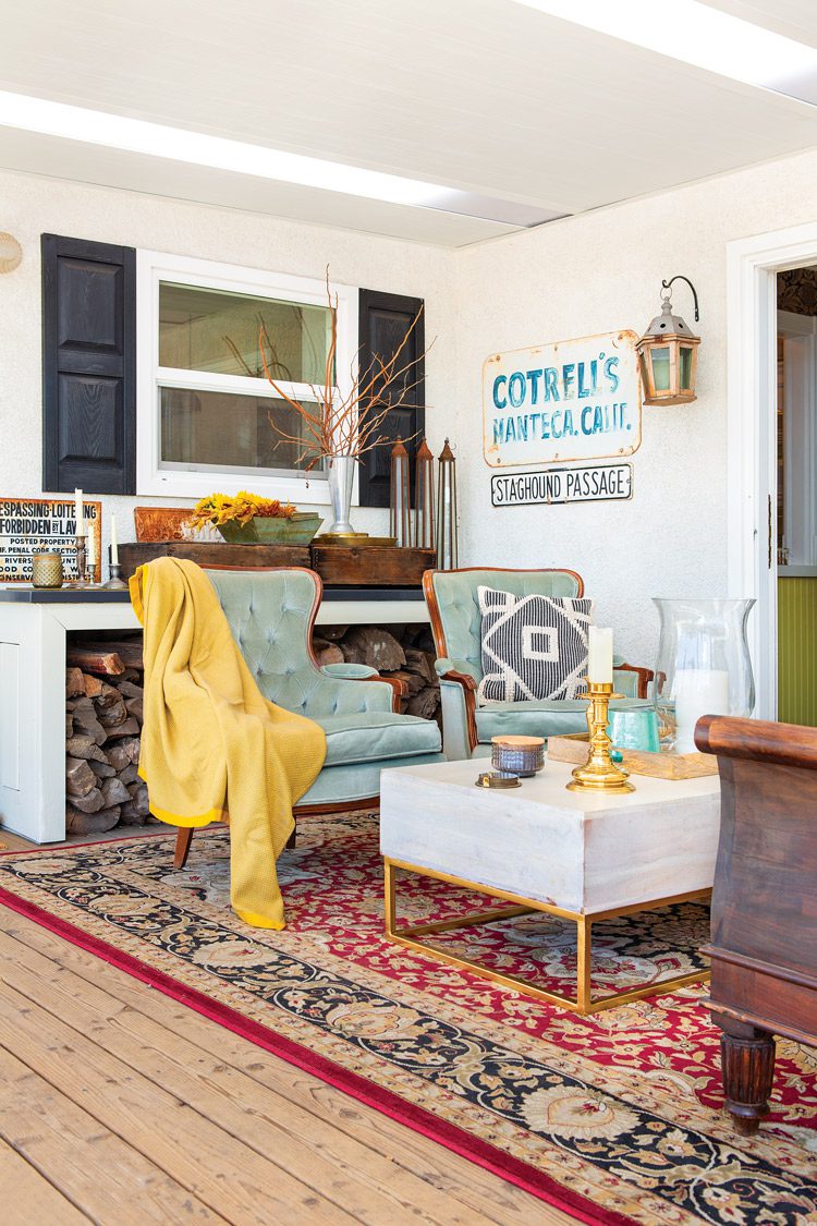 outdoor living room with mint green armchairs and rug