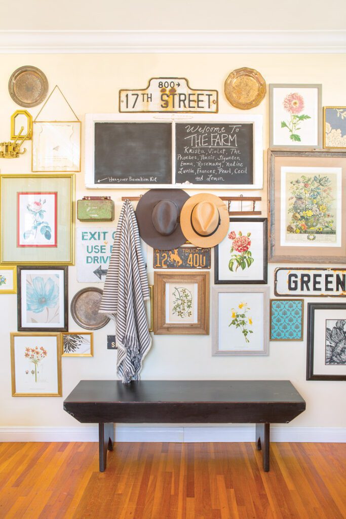 entryway gallery wall with framed prints and flea market signs