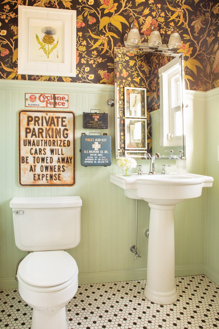 bathroom with floral wallpaper and repurposed vintage flea market signs