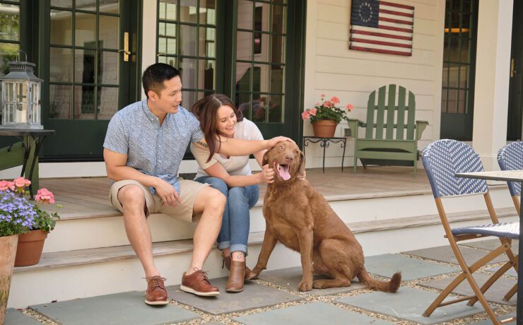 Couple sitting on patio with dog