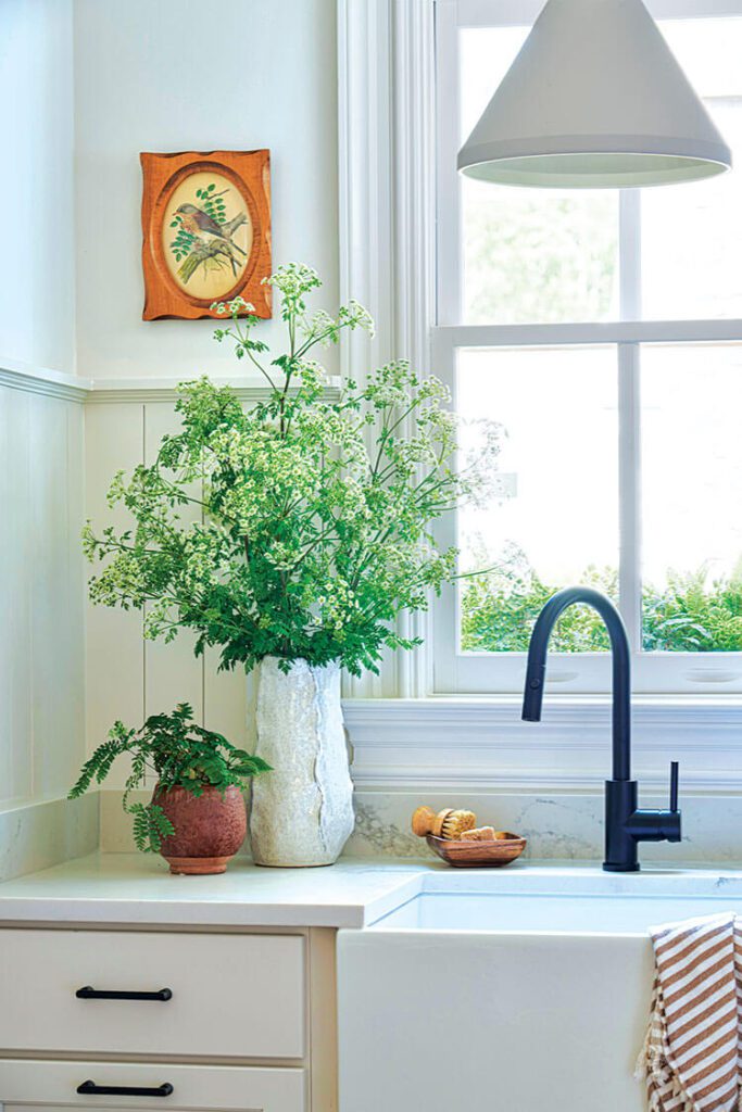 Mudroom sink with vintage painting and fresh bouquets of flowers