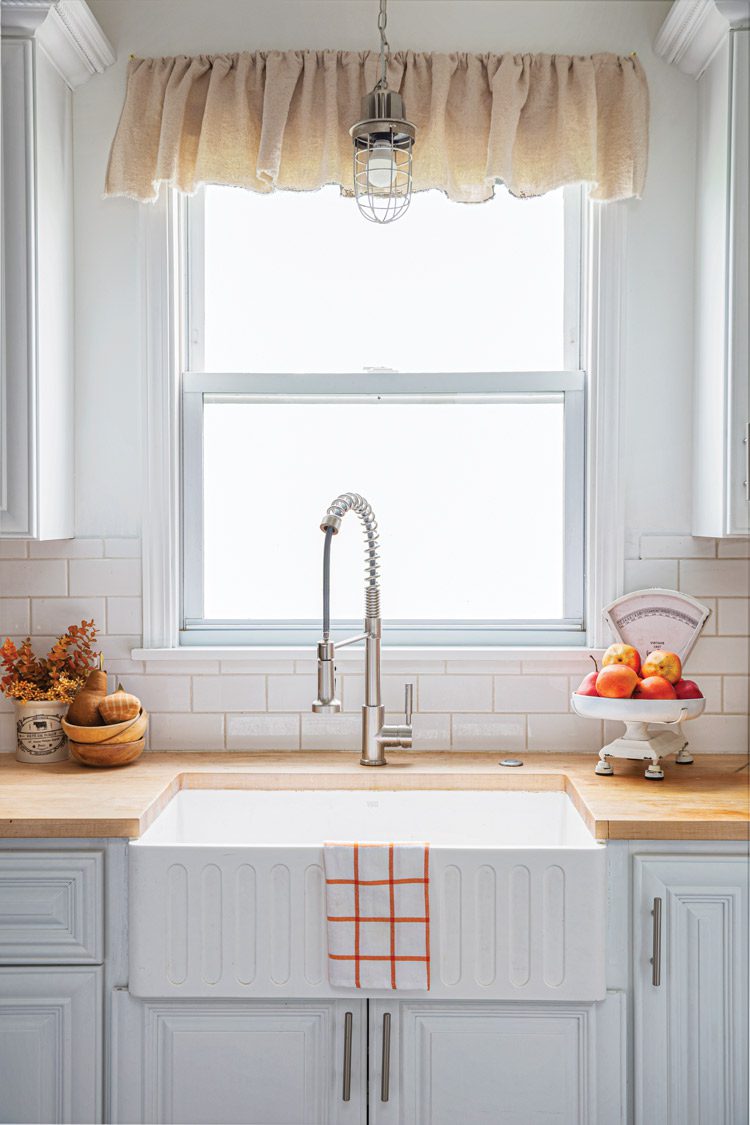 farmhouse kitchen with steel cage lighting and white subway tile