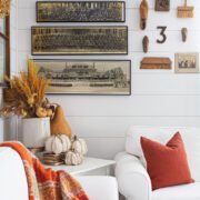 Wall with vintage military photographs lines up on the wall and pumpkins on table in front