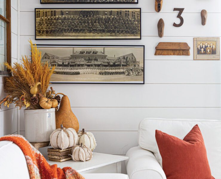 Wall with vintage military photographs lines up on the wall and pumpkins on table in front