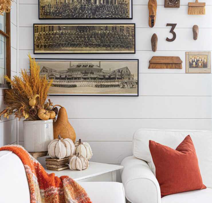 Wall with vintage military photographs lines up on the wall and pumpkins on table in front