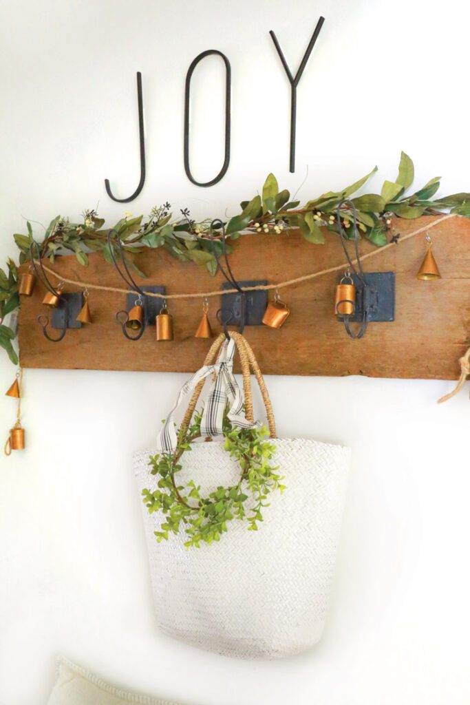rustic bell garland and greenery on coat rack