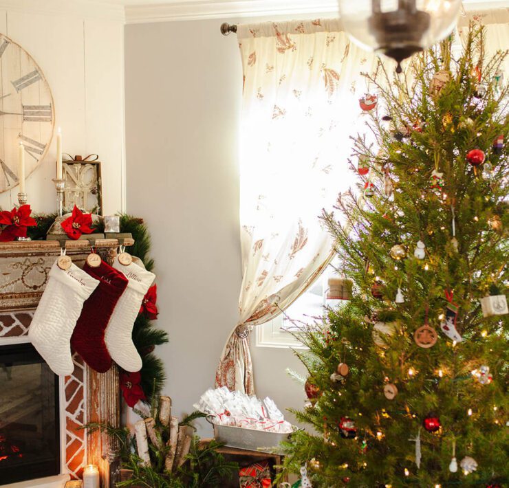 Christmas tree next to mantel with red and white stockings