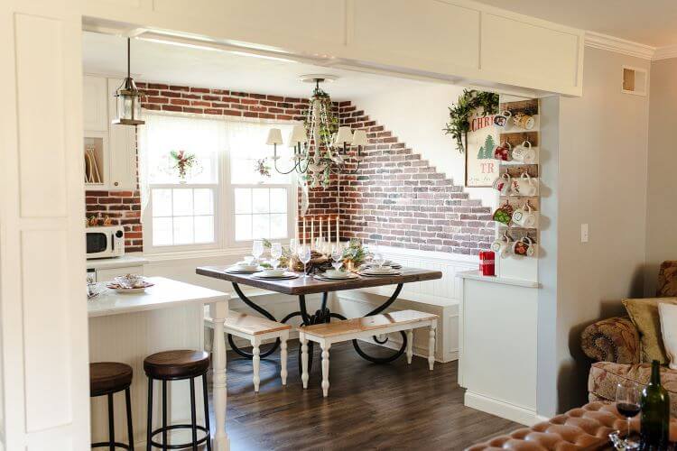 This Pennsylvania Christmas home has a red brick kitchen that is perrfect for a traditional Christmas color palette. White cabinets and evergreen accents complete the look.