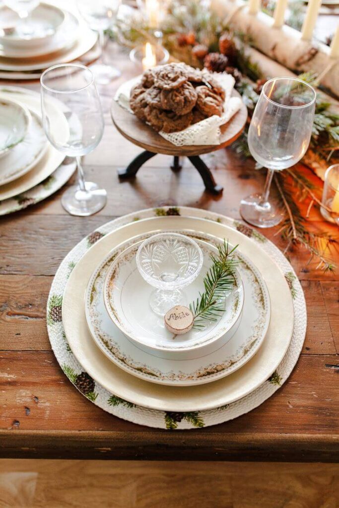 A closeup of the Christmas table spread with pinecone centerpiece and candles