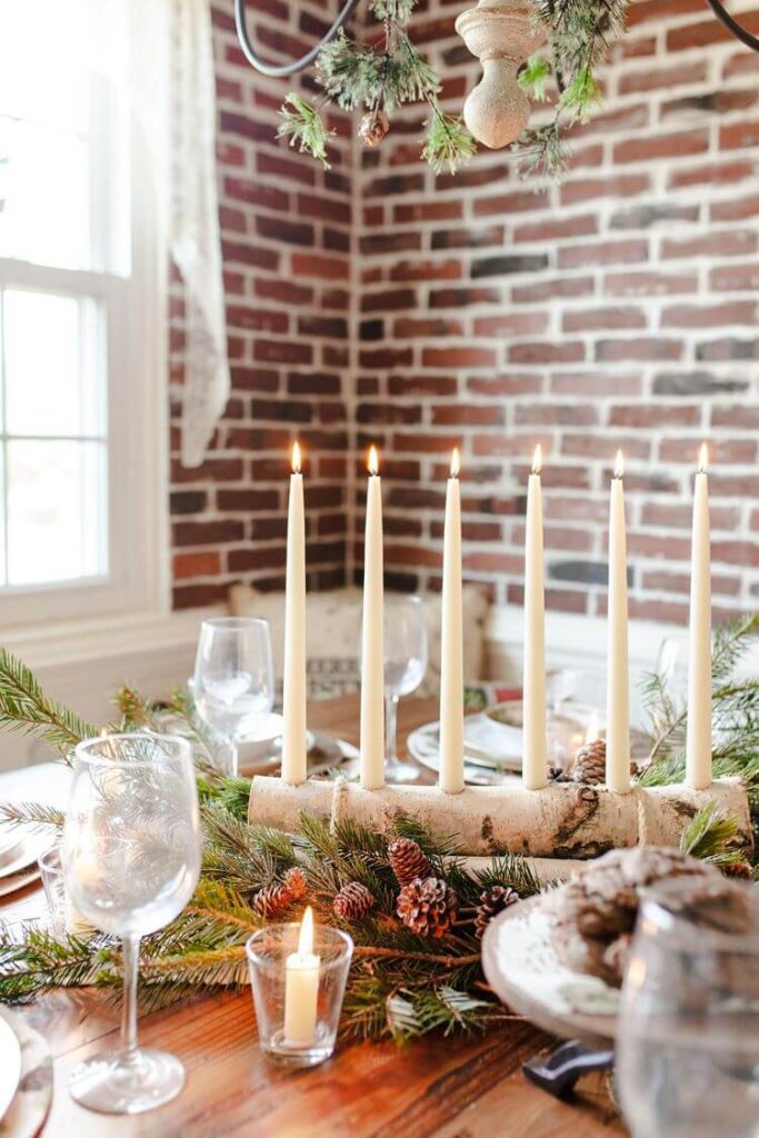 A closeup of the Christmas table spread with pinecone centerpiece and candles
