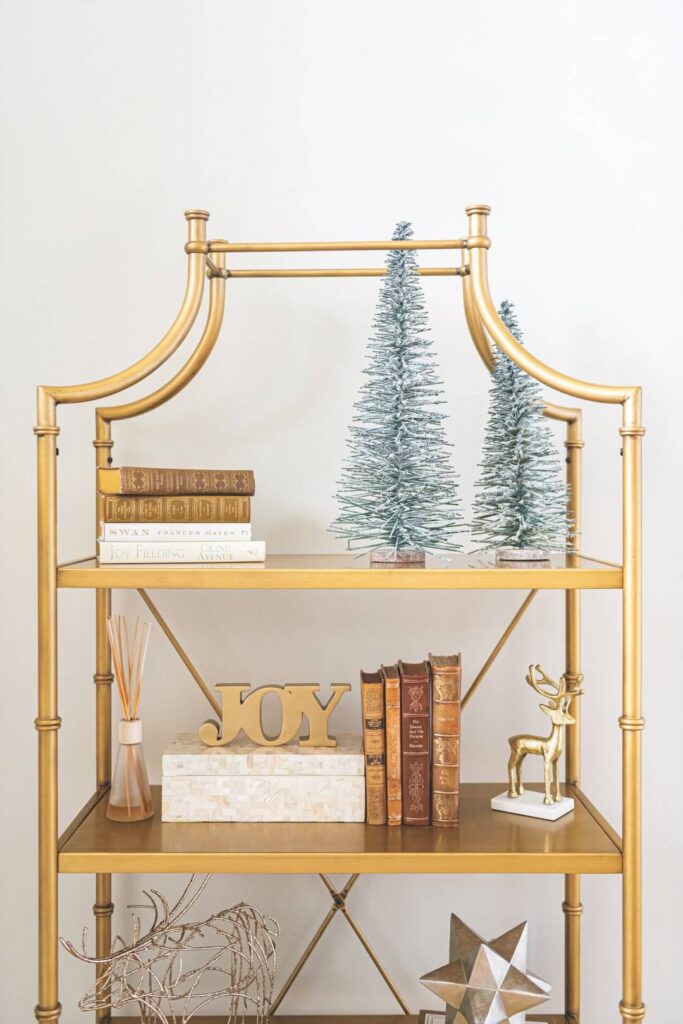 gold bookshelf with holiday decor