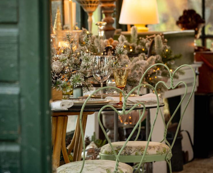 Green iron chairs around a table in a Christmas garden house