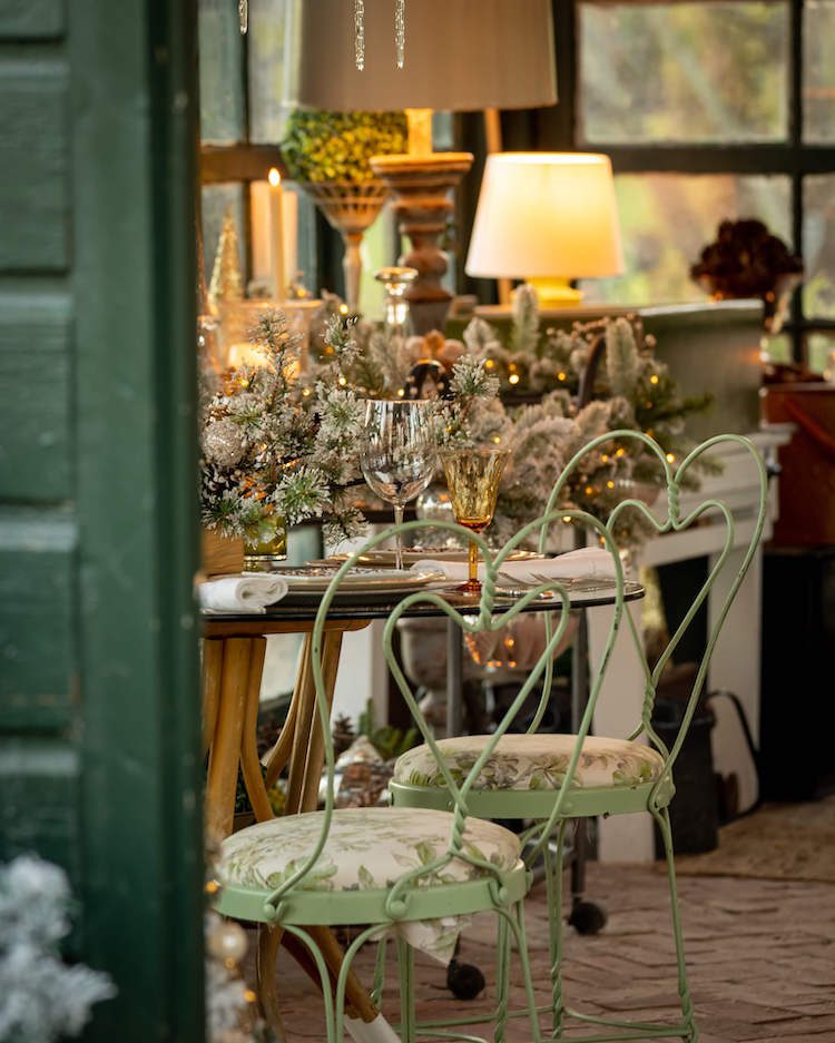Green iron chairs around a table in a Christmas garden house