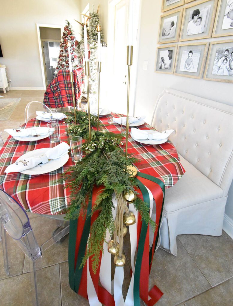 green and red christmas tablescape with gold candle holders and white dishes