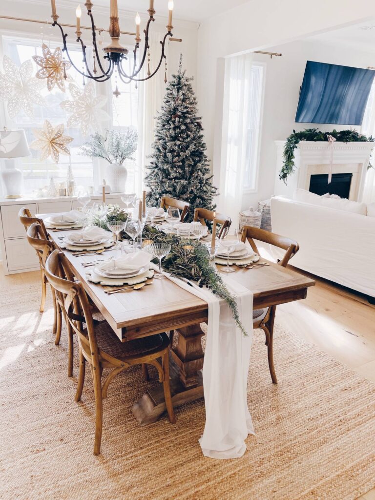 neutral, airy holiday tablescape with light woods, gold cutlery, and white dieshware
