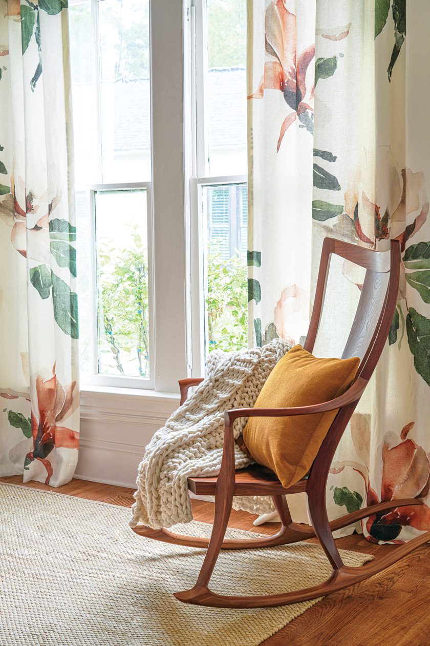 wooden rocking chair and floral curtains