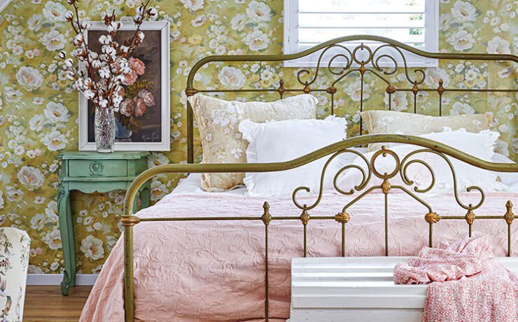bedroom with floral wallpaper and vintage metal bedframe