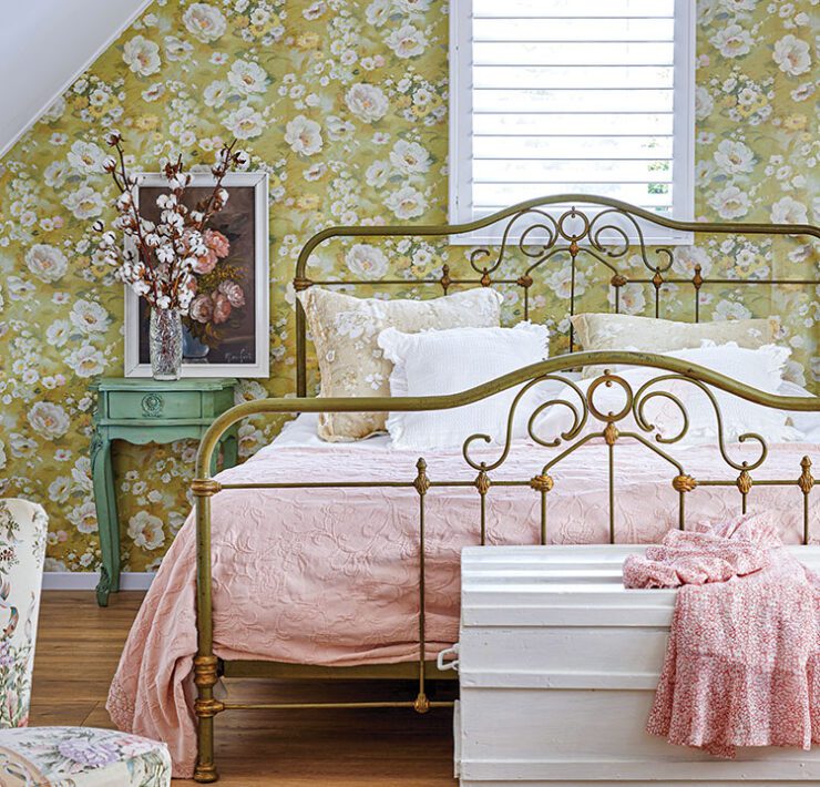 bedroom with floral wallpaper and vintage metal bedframe