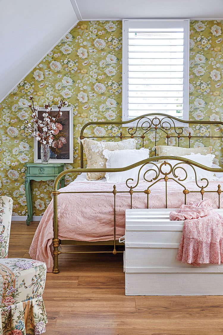 bedroom with floral wallpaper and vintage metal bedframe