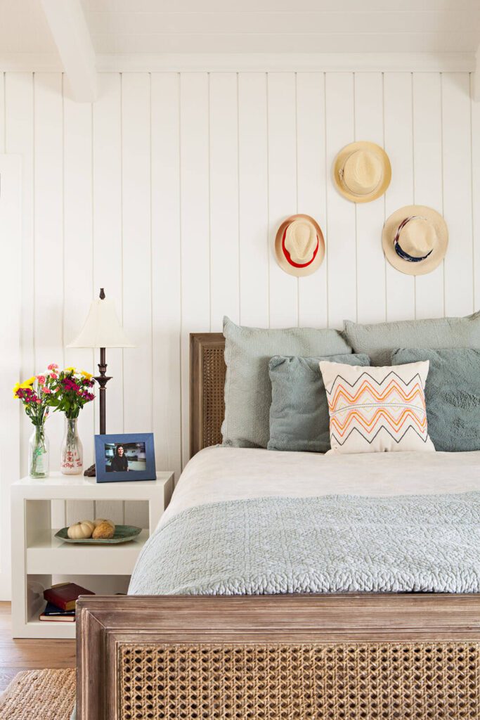 Bedroom with vertical shiplap and hats hanging on the wall