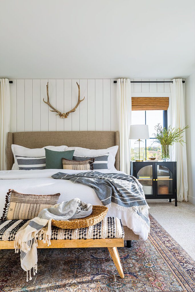 master bedroom with shiplap walls and elk antler decor