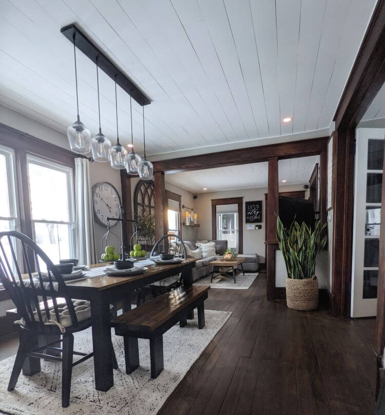 The dining room of this Iowa home got a modern farmhouse update with a shiplap ceiling painted in white and rich walnut trim and flooring