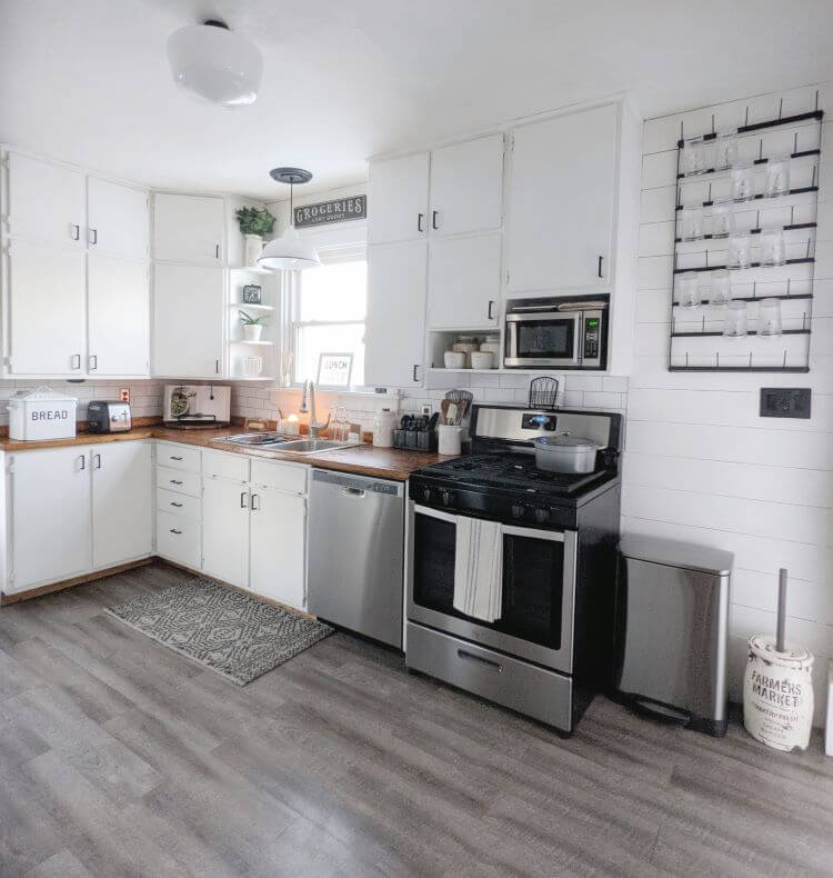 The kitchen is brightened with fresh paint, butcher block countertops, and white subway backsplash.