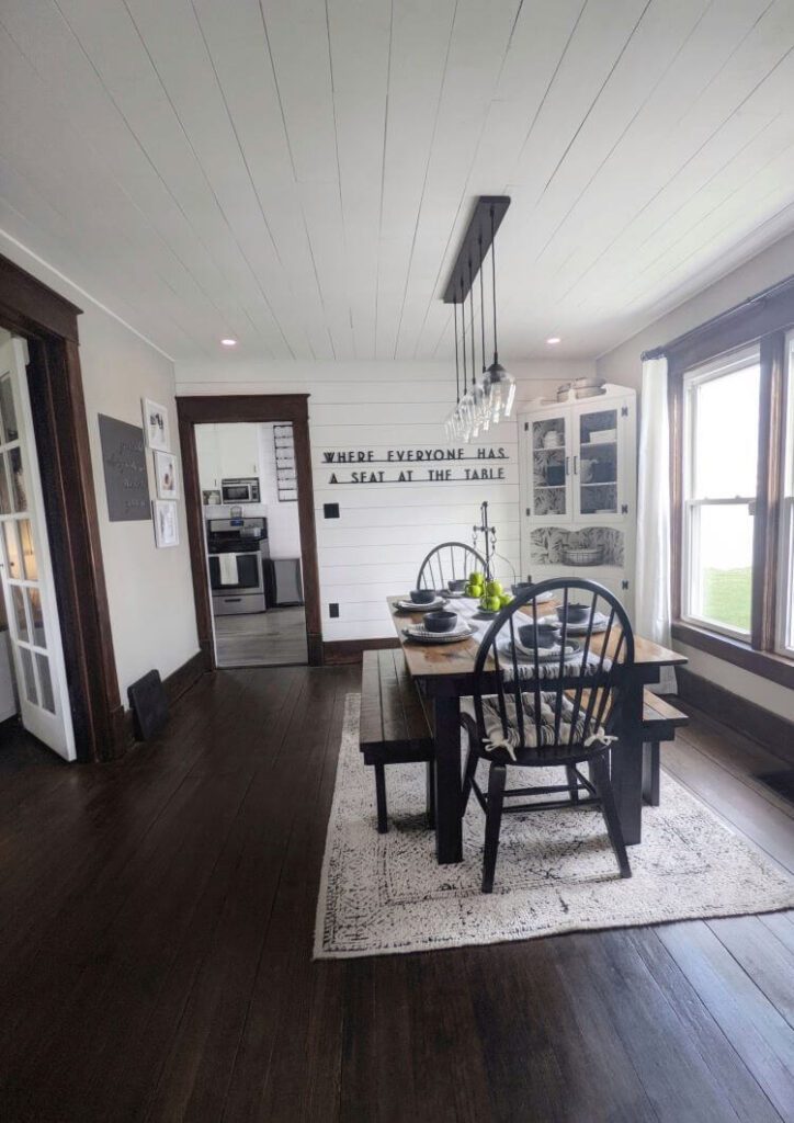 The dining room of this Iowa home got a modern farmhouse update with a shiplap ceiling painted in white and rich walnut trim and flooring
