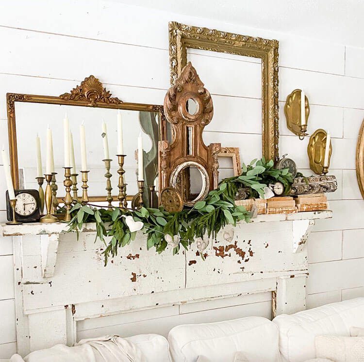 Flea market wall decor on top of a vintage faux mantel with mirrors