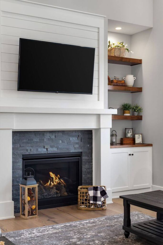 The fireplace has a touch of shiplap painted white to fit the white farmhouse