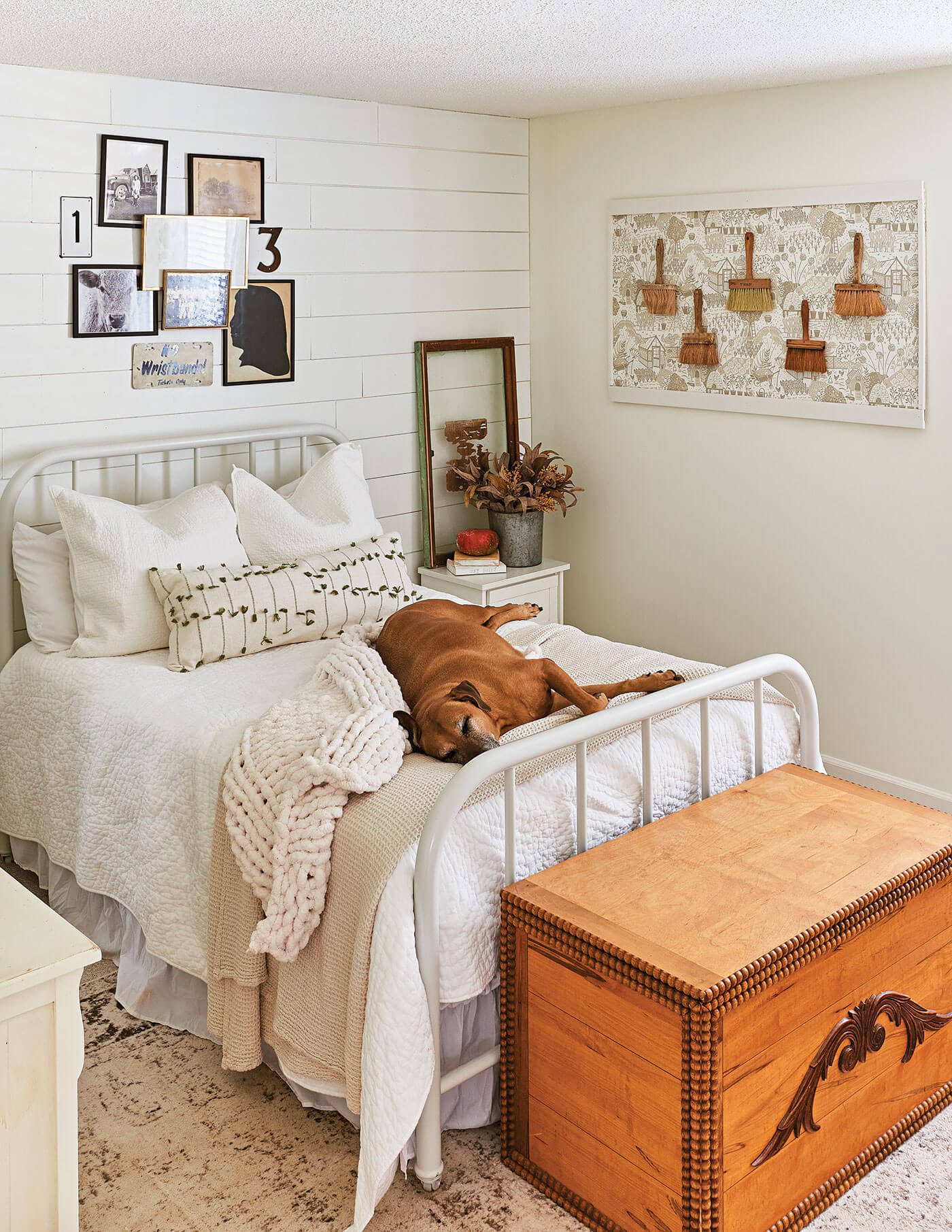 Bedroom with flea market wall decor and dog sleeping on the bed