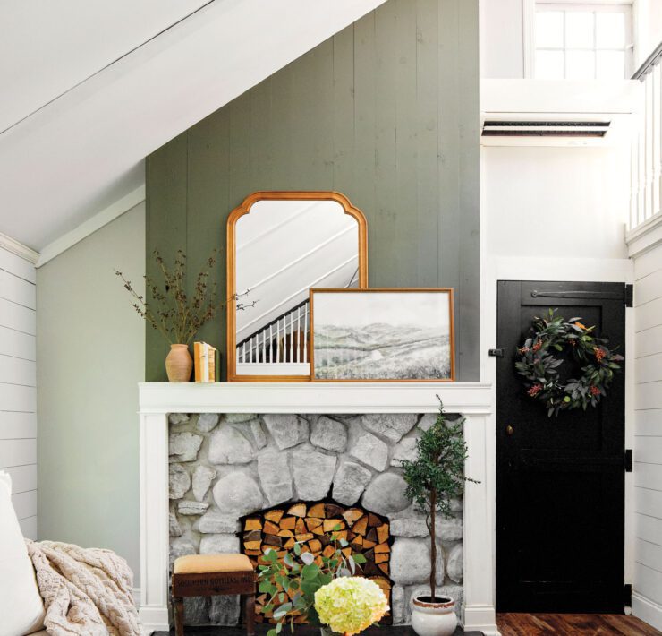 Living room with gren and mantel and cozy decor with a vintage mirror