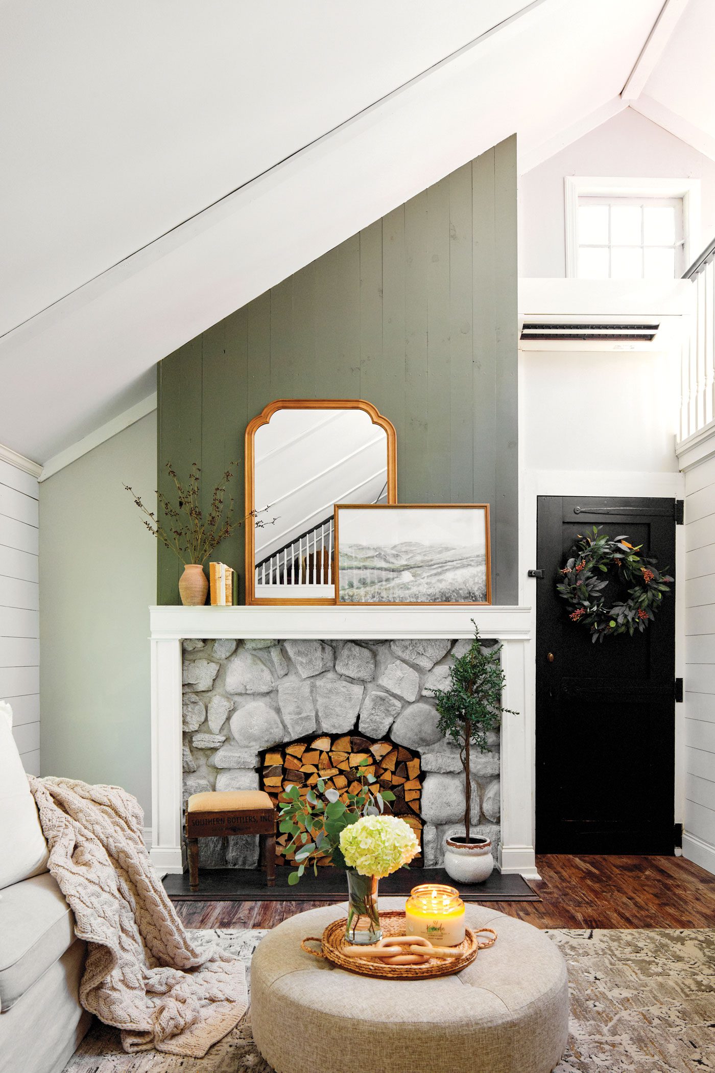 Living room with gren and mantel and cozy decor with a vintage mirror