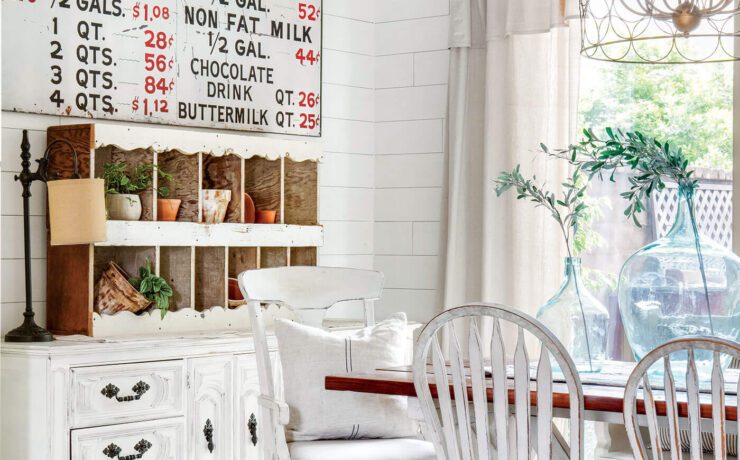 neutral colored dining room with old furniture and exposed ceiling beams