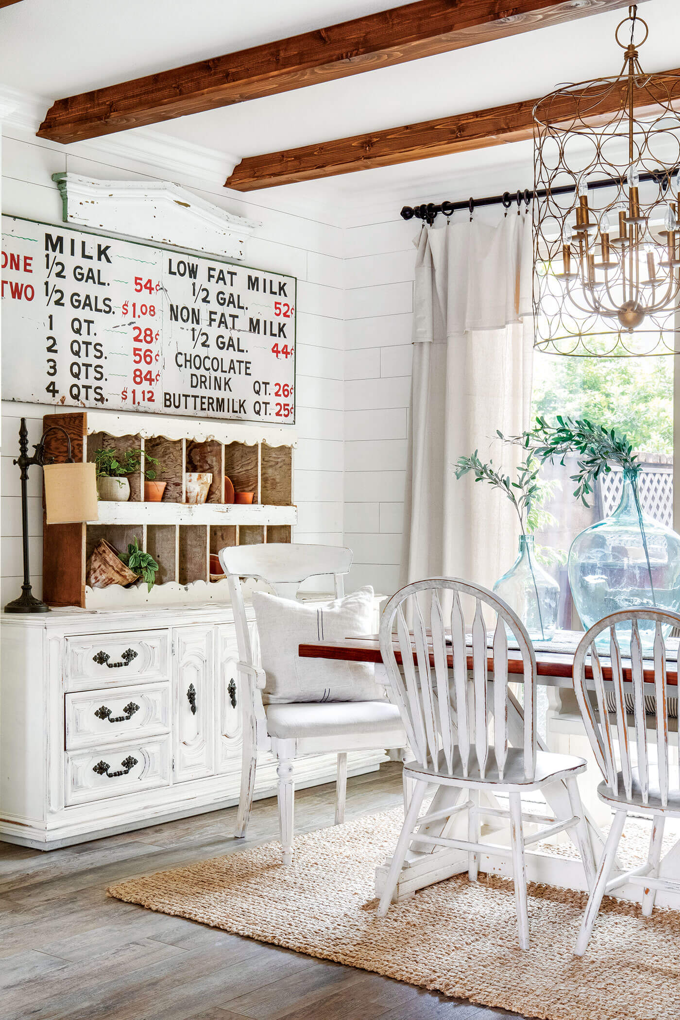 neutral colored dining room with old furniture and exposed ceiling beams