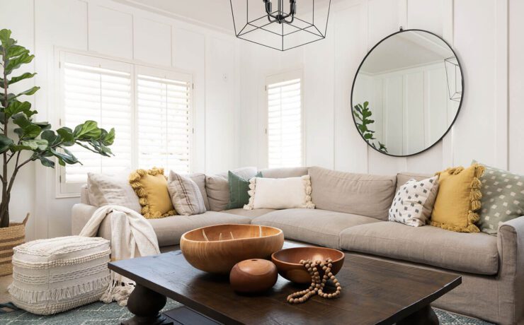 Living room with yellow pillows, gray sofa and wall paneling for boho farmhouse style.